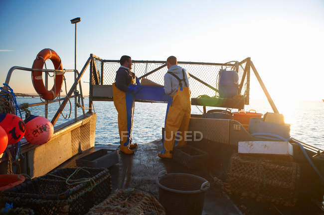 Fishermen at work on boat — Stock Photo