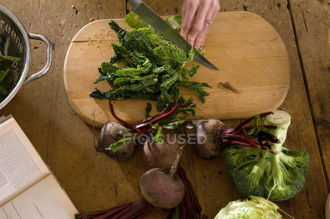 Mão feminina cortar legumes — Fotografia de Stock