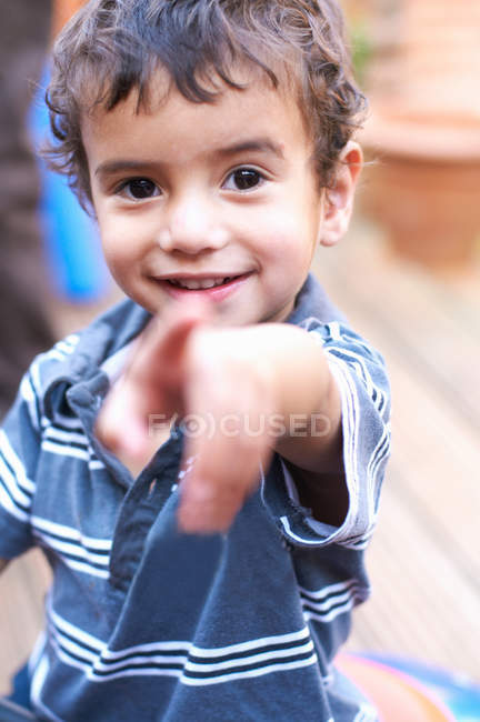 Rapaz sorridente apontando para a frente — Fotografia de Stock