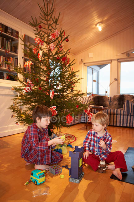 Jungen spielen unter dem Weihnachtsbaum — Stockfoto