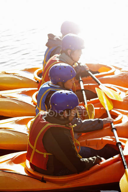Каякеры гребут вместе на озере — стоковое фото