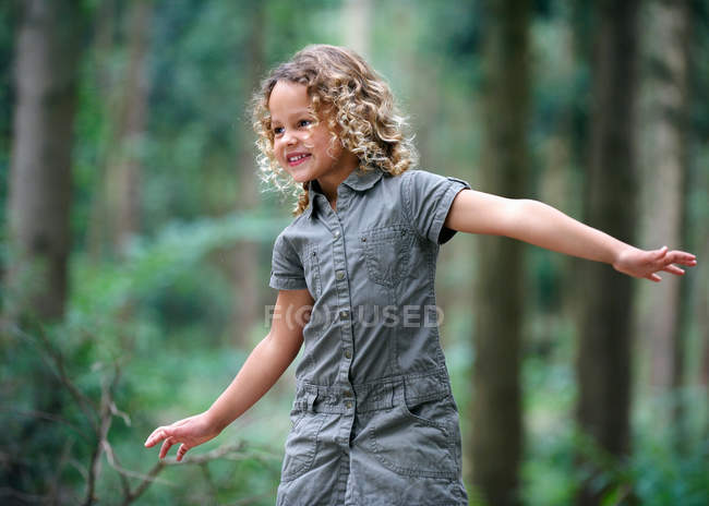 Young girl arms outstretched woodland — Stock Photo