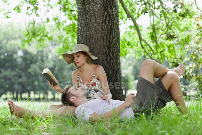 Couple relaxing under tree together — Stock Photo