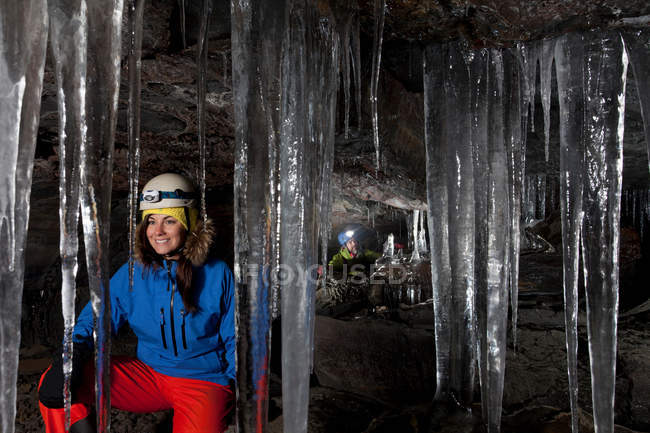 Турист с сосульками в ледниковой пещере — стоковое фото