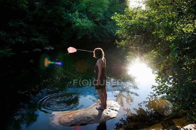Woman catching fish with net — Stock Photo