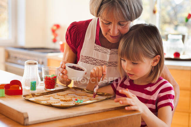 Grandma and grandchild baking biscuits — Stock Photo
