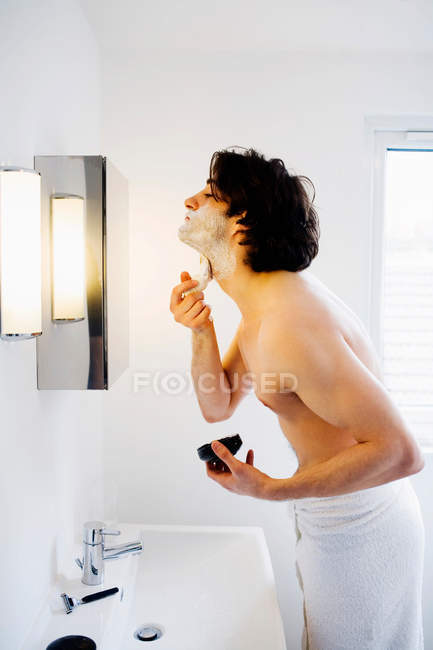 Hombre espuma de afeitar espuma de afeitar en el baño - foto de stock
