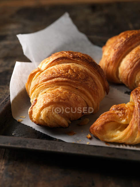 Frisch gebackene Croissants auf Blech — Stockfoto
