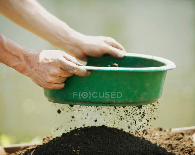 Hands sifting soil outdoors — Stock Photo