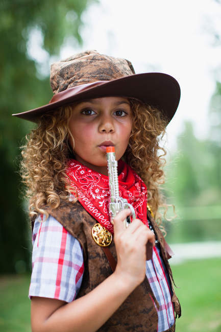 Menina em chapéu de cowboy com pistola de brinquedo — Fotografia de Stock