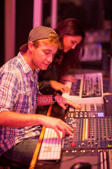 Молодой человек и женщина в студии звукозаписи колледжа — стоковое фото
