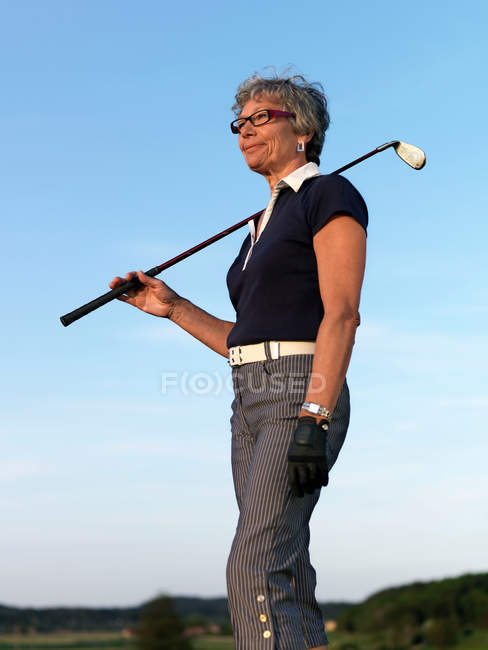 Mulher segurando clube de golfe — Fotografia de Stock
