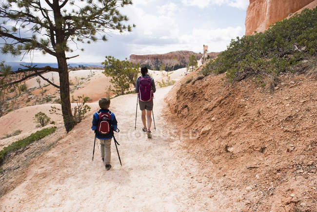 Madre e hijo, haciendo senderismo en el Queens Garden / Navajo Canyon Loop en el Parque Nacional Bryce Canyon, Utah, EE.UU. - foto de stock