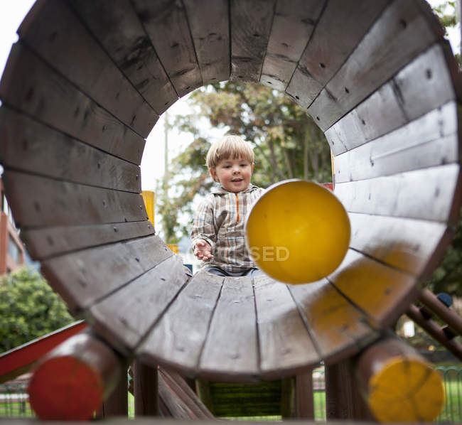 Junge spielt auf Spielplatz mit Ball — Stockfoto