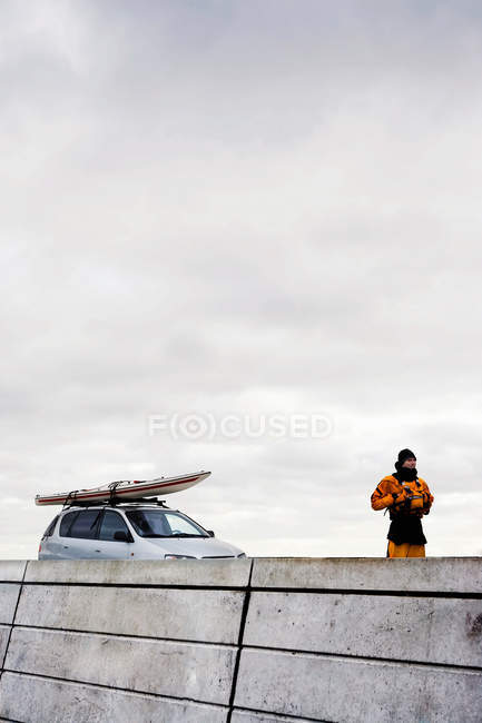 Человек перед машиной с каяком — стоковое фото