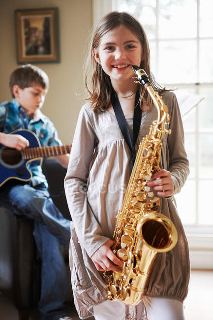Sorridente ragazza suonare il sassofono — Foto stock