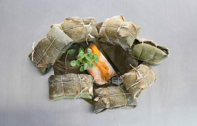 Tamales wrapped in banana leaves with butternut squash — Stock Photo
