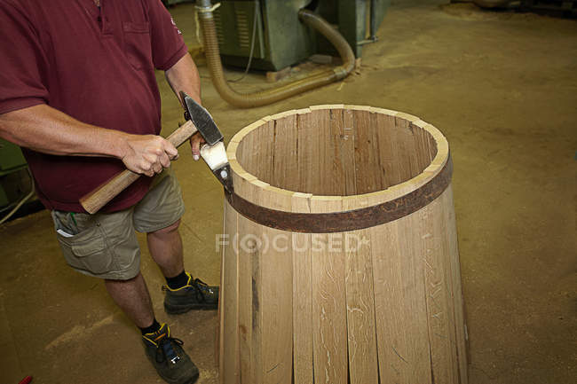 Trabalhador martelando barril na loja — Fotografia de Stock