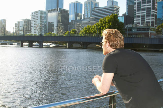 Homem com vista para o rio urbano na ponte — Fotografia de Stock