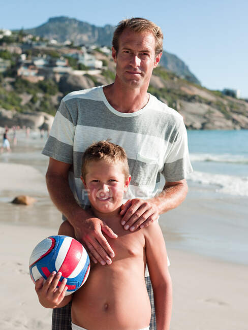 Padre e hijo en la playa con pelota - foto de stock