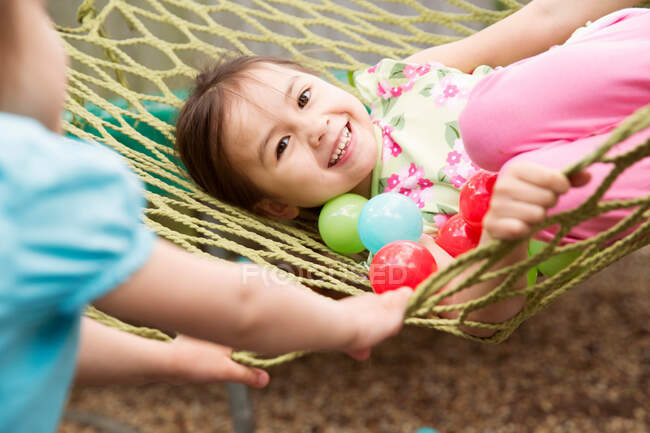 Young girl in hammock with colored balls — Stock Photo