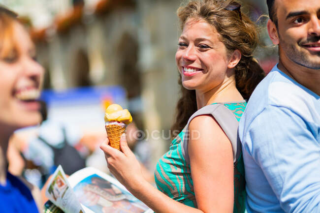 Woman eating ice cream, smiling — Stock Photo
