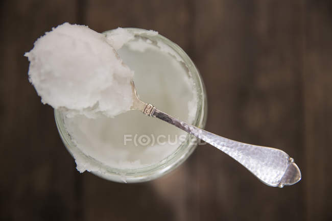 Вид сверху ложки холодного кокосового масла на банку — стоковое фото