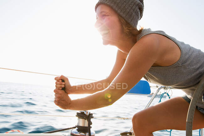 Woman pulling rigging on boat — Stock Photo