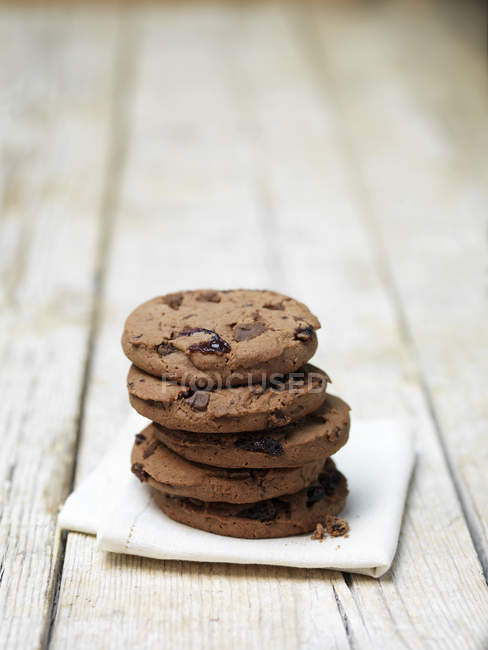 Stack of black cookies on tea towel — Stock Photo