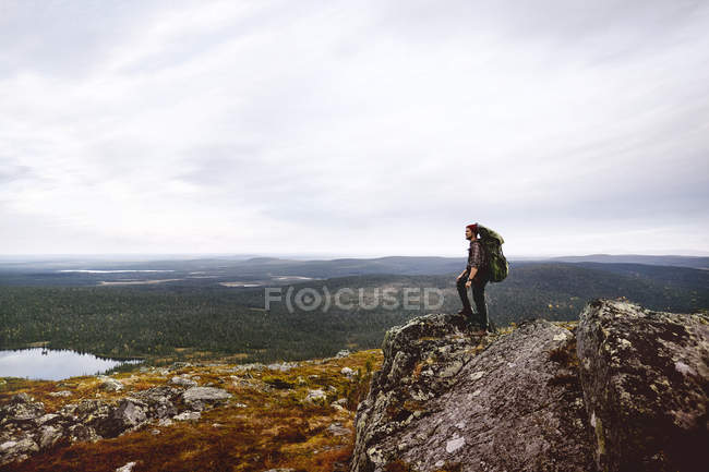 Senderista disfrutando de la vista en la cima del acantilado, Keimiotunturi, Laponia, Finlandia - foto de stock