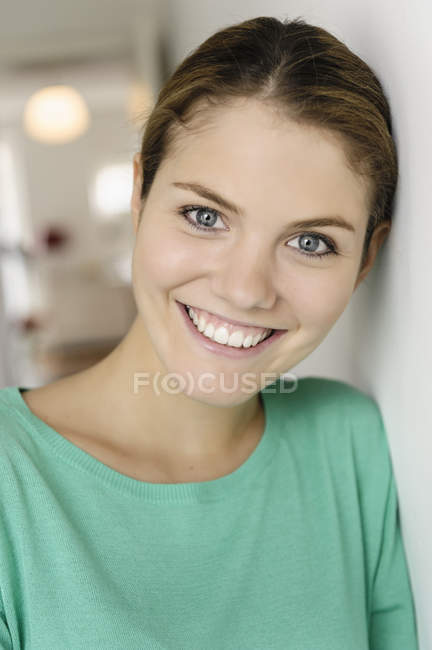 Close up portrait of young woman leaning against wall — Stock Photo