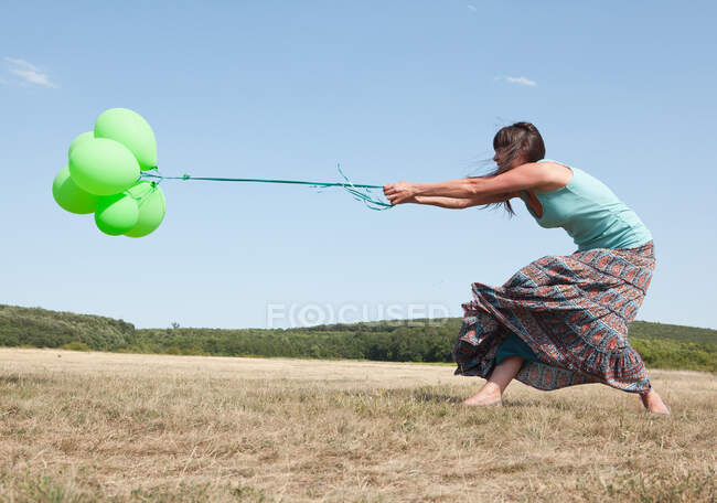 Mulher carregando um monte de balões — Fotografia de Stock
