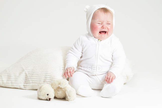Portrait de bébé fille en pleurs et ours en peluche — Photo de stock