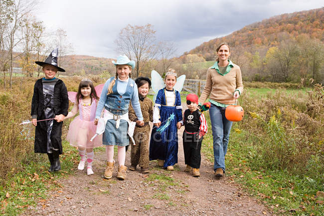 Woman and children trick or treating — Stock Photo