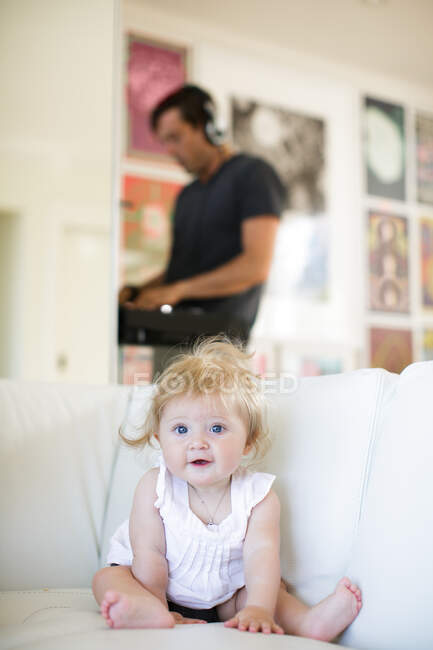 Portrait de bébé fille assise sur le canapé — Photo de stock