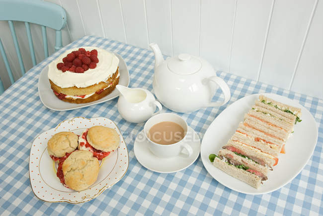 Tea with sandwiches and cakes — Stock Photo