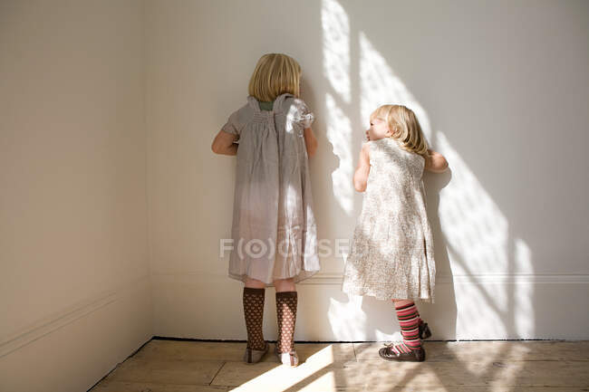 Chicas de pie contra una pared - foto de stock