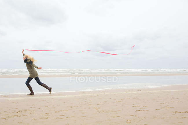 Donna con nastro in riva al mare — Foto stock