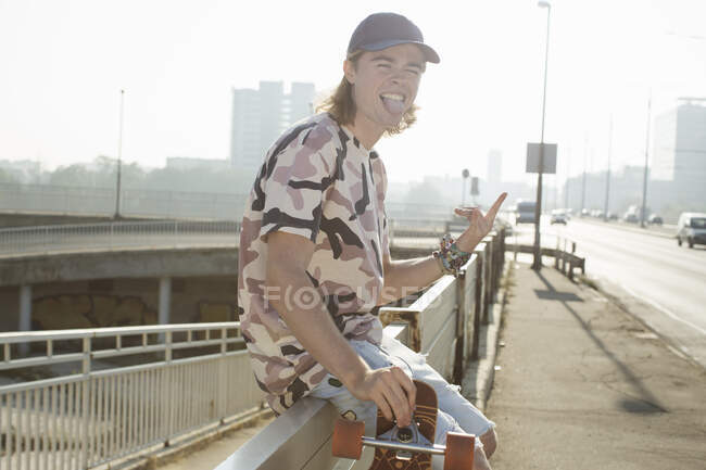 Skateboarder sticking tongue out, Budapest, Hungría - foto de stock