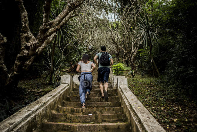 Rear view of couple running up steps to Mount Phousi, Luang Prabang, Laos — Stock Photo