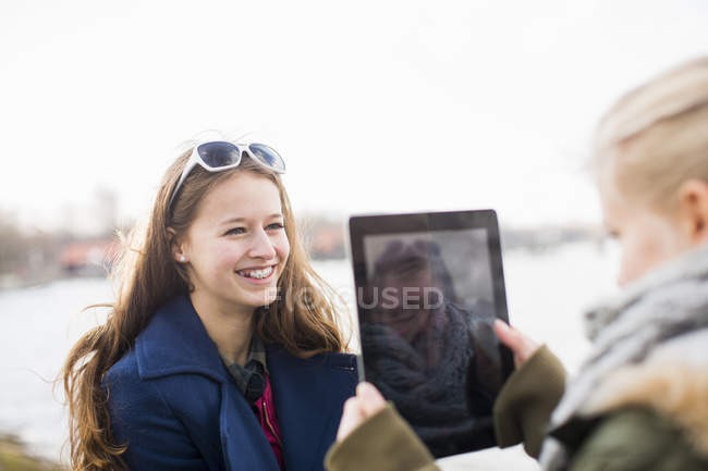 Девушка-подросток фотографирует друга с помощью цифрового планшета — стоковое фото