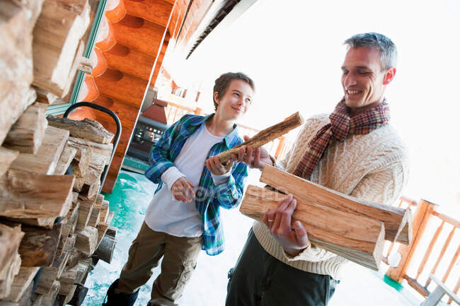 Father and son holding logs — Stock Photo