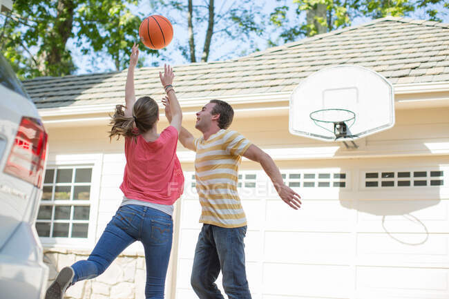 Hermano y hermana jugando baloncesto - foto de stock