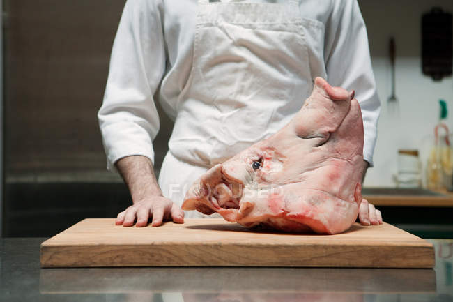 Schlachter mit Schweinekopf — Stockfoto