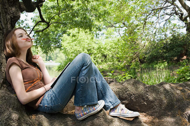 Girl sitting on a tree trunk — Stock Photo