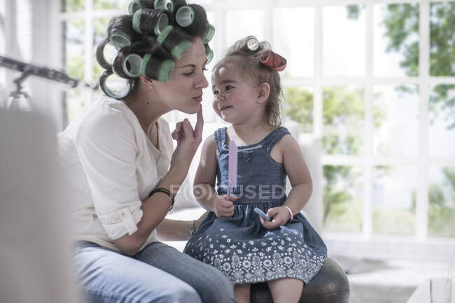Cape Town, Afrique du Sud, mère moderne avec des boucles dans les cheveux demandant un baiser à son enfant — Photo de stock