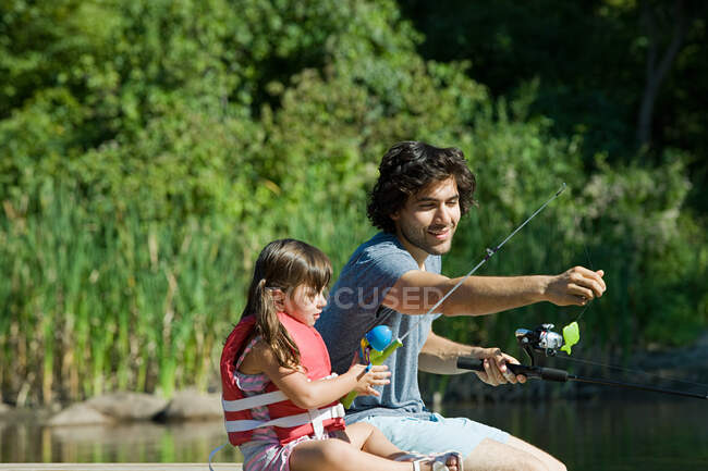 Отец и дочь рыбачат — стоковое фото