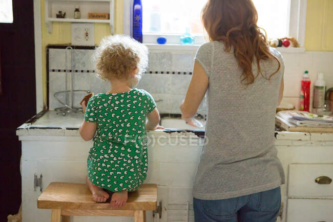 Madre e hijo en el fregadero de cocina - foto de stock