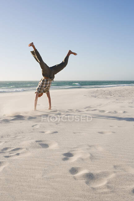 Un jeune homme faisant un handstand — Photo de stock