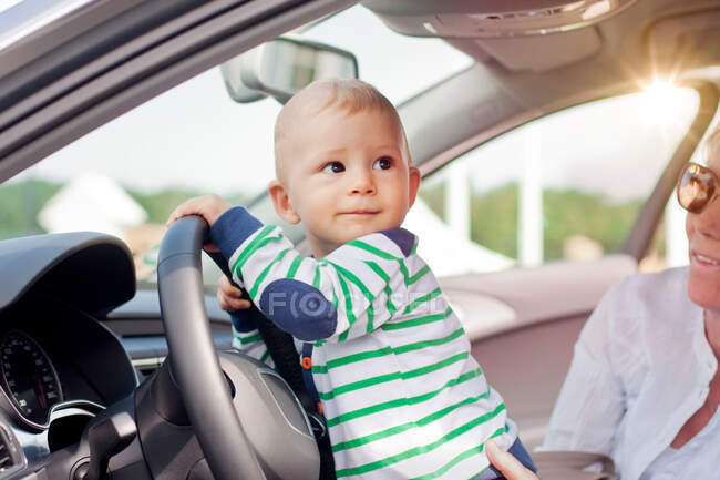 Малыш играет с рулем — стоковое фото